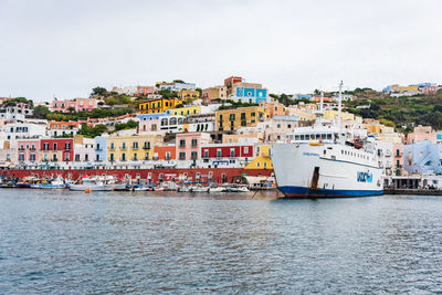 Buildings by sea against sky in town