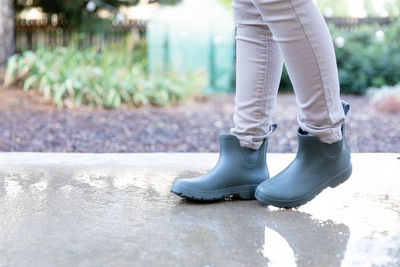 Woman wearing rain boots walking in a sidewalk