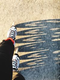 Low section of person roller skating on road