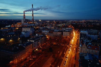 Steam from pipes over night city, aerial view