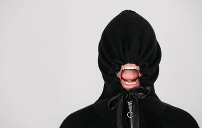 Portrait of person with hood against white background