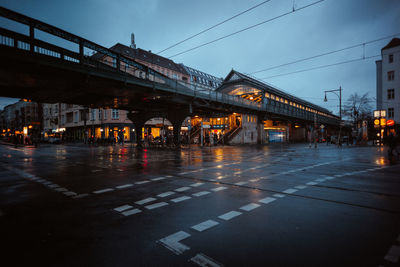 Illuminated bridge over road in city at night