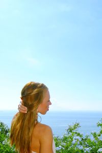 Woman looking at sea against sky