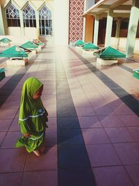 Rear view of woman on floor against building