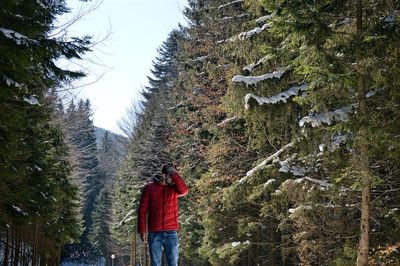 Man walking on tree against sky