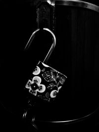 Close-up of padlocks hanging against black background
