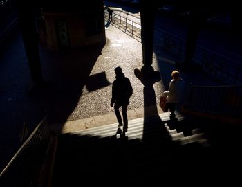 High angle view of silhouette people walking on sidewalk in city
