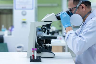 Man working over microscope in laboratory