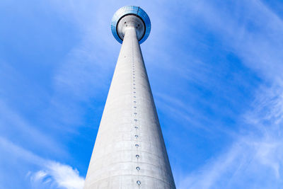 Low angle view of communications tower against cloudy sky
