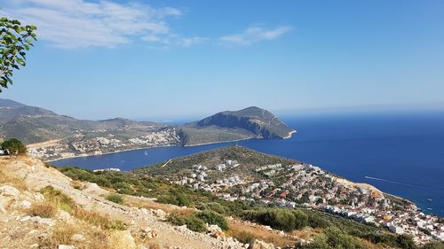 Scenic view of sea and mountains against blue sky