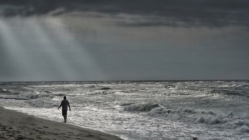 Man standing on beach against sky