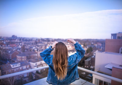 Rear view of woman photographing cityscape