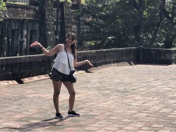 Full length of woman standing on footpath