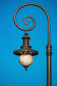 Low angle view of street light against blue sky