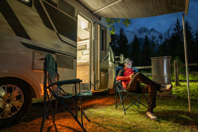 Rear view of woman sitting on field