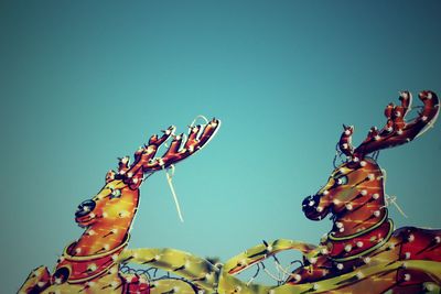 Low angle view of reindeer sculpture against sky during christmas