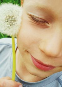 Close-up of boy with hand on flower