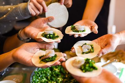 Cropped image of hands holding dumplings