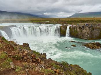 Scenic view of waterfall against sky