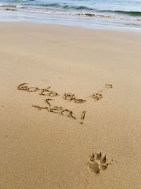 High angle view of text on sand at beach