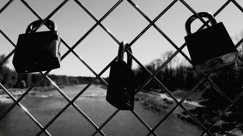 Close-up of padlocks on chainlink fence against clear sky