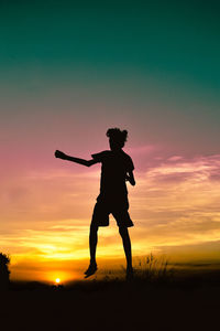 Silhouette man standing on beach against sky during sunset