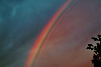 Low angle view of rainbow against sky at sunset