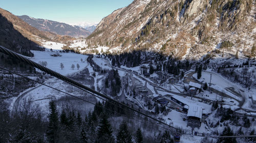 Aerial view from snow austria alps on winter valley and village near cable road