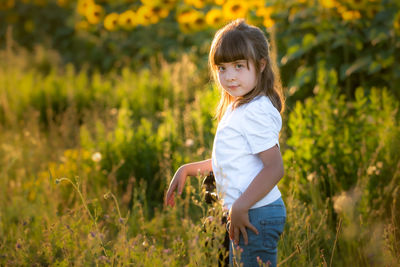 Girl looking away while standing on field