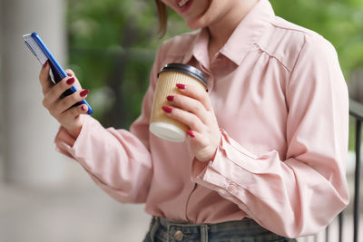 Midsection of woman using mobile phone