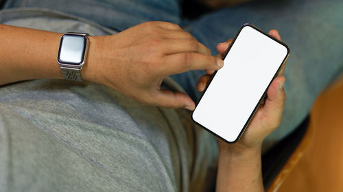 Midsection of man using mobile phone