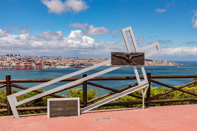 Cross of jesus with the view of lisbon old town over the tagus river, almada on cristo rei, portugal