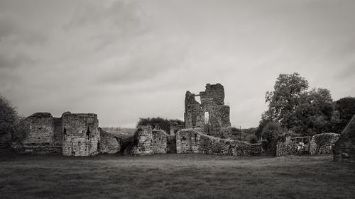 Old ruins of building on field against sky