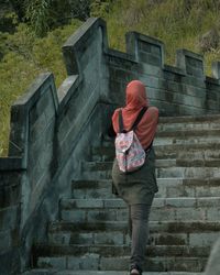 Rear view of woman standing on staircase