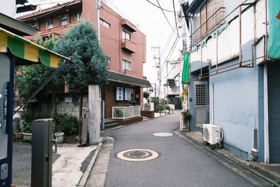 Empty road amidst buildings in city