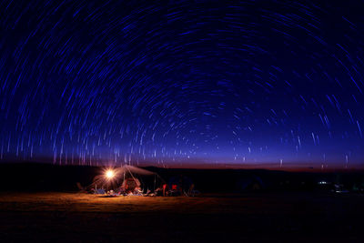 Scenic view of star trails over field at night