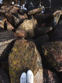 Low section of man standing on rock