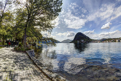 Scenic view of mountains by lake lugano against sky