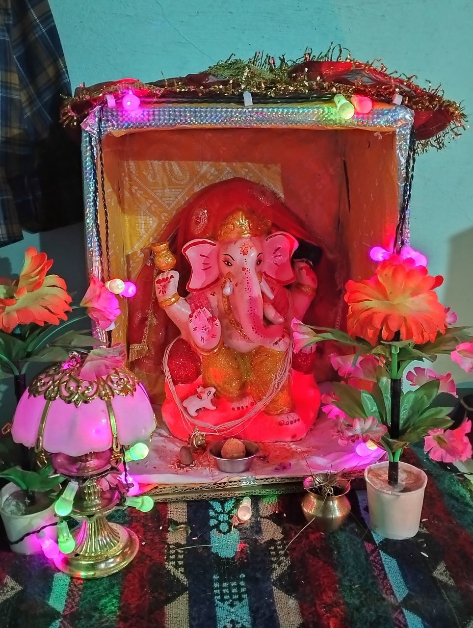 flower, flowering plant, religion, pink, belief, spirituality, no people, representation, plant, human representation, sculpture, statue, creativity, nature, multi colored, architecture, craft, indoors, place of worship, temple - building, male likeness, tradition, decoration, close-up, built structure