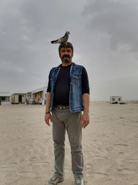 Full length of man standing on beach against sky