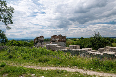 Built structure on field against cloudy sky