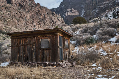 Old house on field by mountain