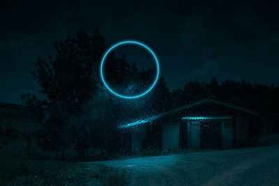 View of illuminated circle against trees at night