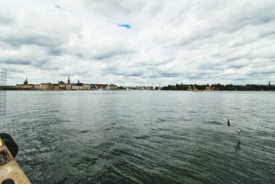 Scenic view of river against cloudy sky