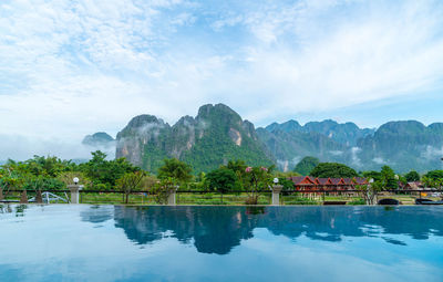 Scenic view of lake by mountains against sky