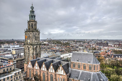 Aerial view of city buildings against cloudy sky