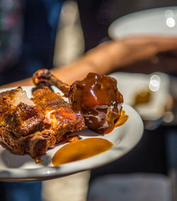 Close-up of hand holding food served in plate