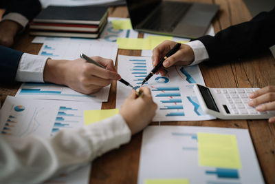 Midsection of business colleagues working on table