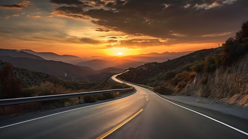 Empty road against sky during sunset