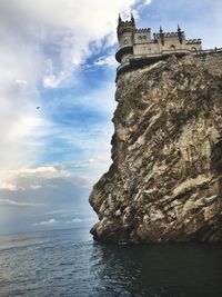 Rock formations by sea against sky